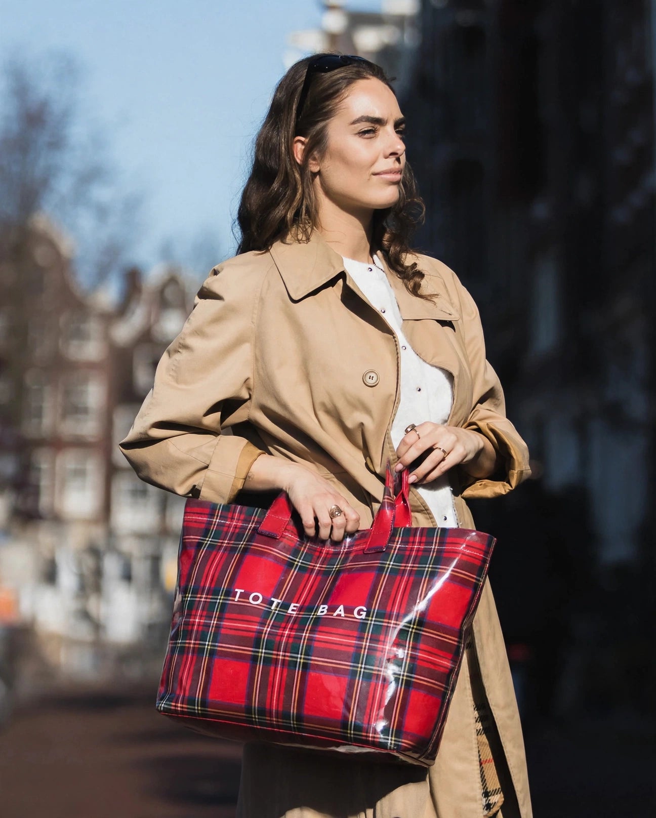 Red Plaid tote carried by hand on a city street