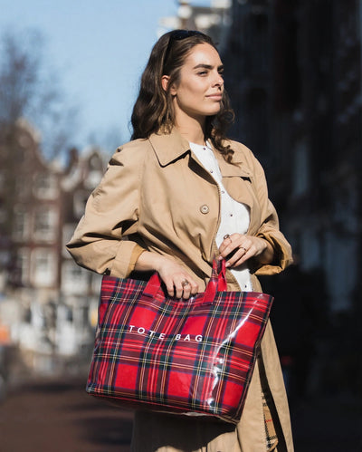 Red Plaid tote carried by hand on a city street